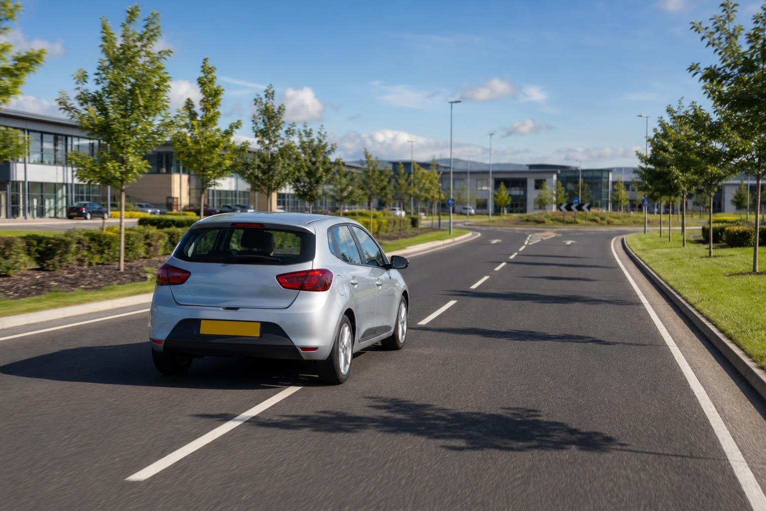 Compact hire car driving through a suburban business route near Wigan